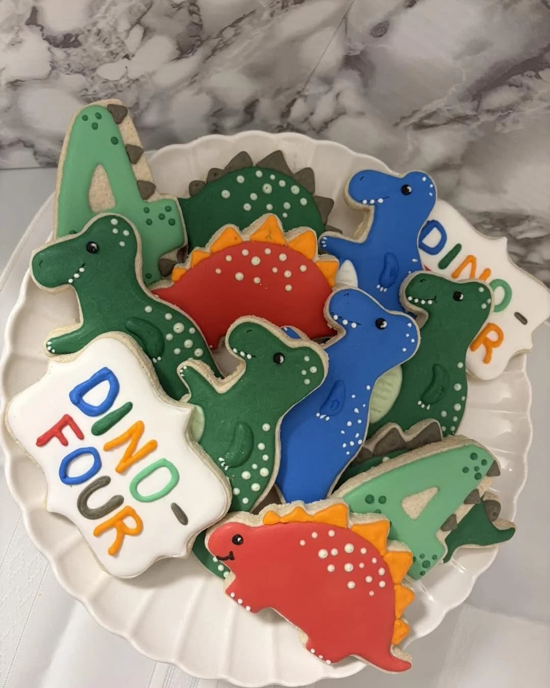 Kids' birthday dinosaur cookies with 'DINO FOUR' lettering