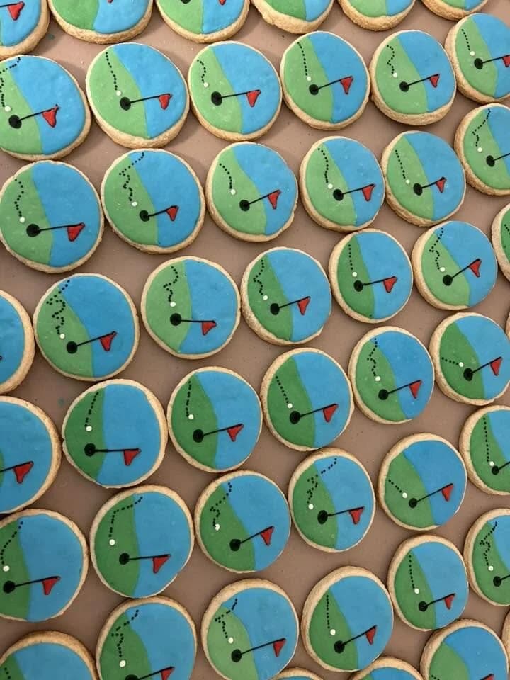 Round golf-course themed cookies with green fairway and red flag pins